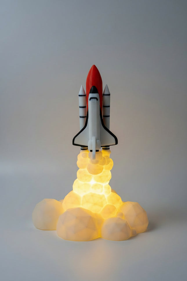 A small space shuttle model displayed on a glowing yellow base that simulates exhaust, set against a dimly lit wall and wooden surface.